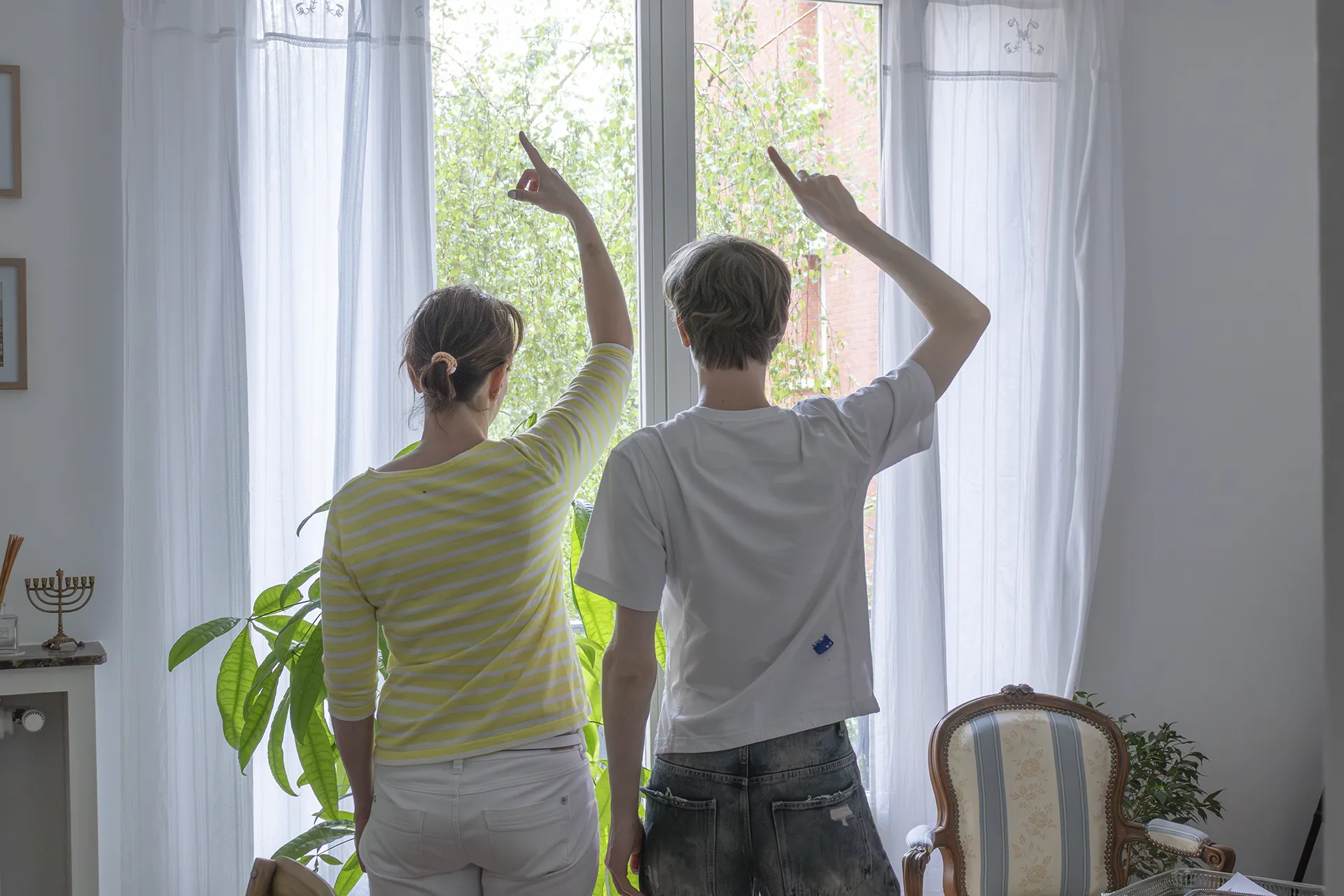 Emile et sa mère font un signe du doigt de dos